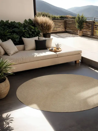 Terrasse mit Lounge-M&ouml;beln, rundem Outdoor Teppich und stilvoller Gartendekoration