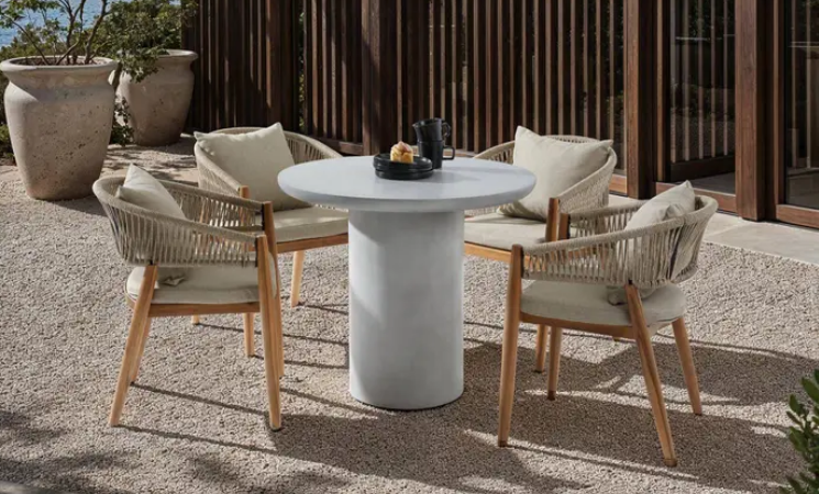 Runder Gartentisch mit vier Outdoor-St&uuml;hlen und Sitzkissen auf moderner Terrasse