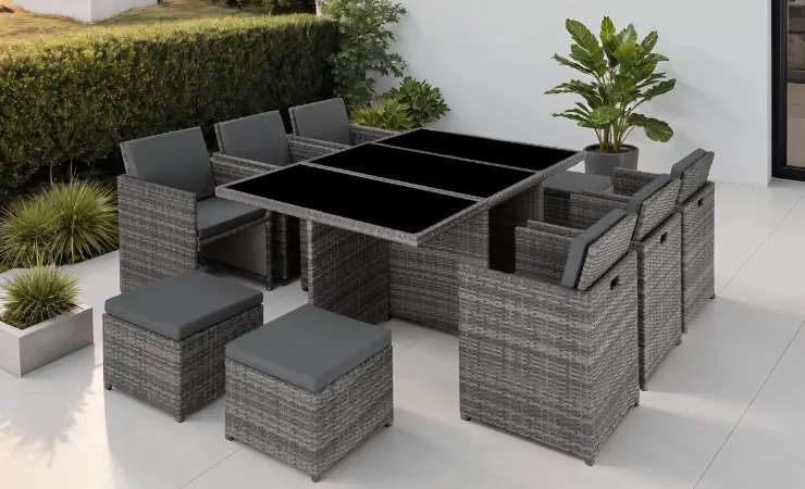 Outdoor-Lounge am Pool: runder wei&szlig;er Tisch mit Wasserflasche, im Hintergrund Rattanm&ouml;bel.