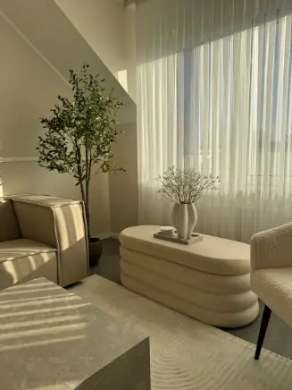 Polsterbank Altu in beige vor lichtdurchflutetem Fenster mit Vase &ndash; minimalistisches Clean-Living-Design