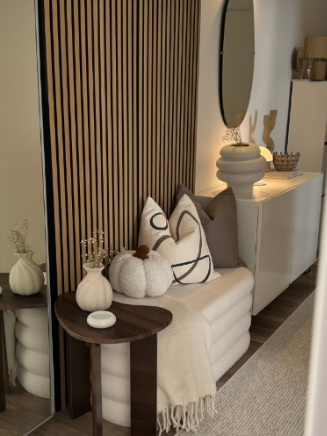 Warm Modern Sitzecke mit Holzlamellen, Kissen und dunklem Beistelltisch