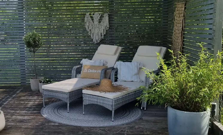 Bequeme Sonnenliegen mit Polstern in ruhiger Gartenumgebung